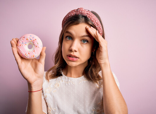 Young,Blonde,Girl,Eating,Sweet,Bakery,Sugar,Doughnut,Over,Pink