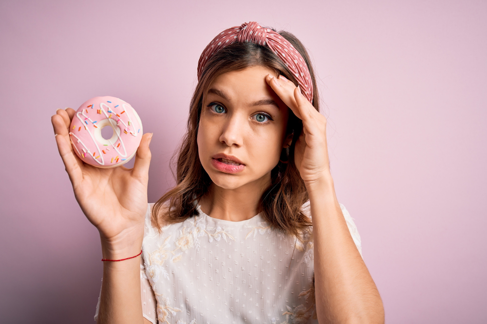 Young,Blonde,Girl,Eating,Sweet,Bakery,Sugar,Doughnut,Over,Pink