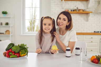 Portrait,Of,Smiling,Mother,And,Child,At,Kitchen,Table,With