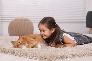 Smiling,Little,Girl,And,Cute,Ginger,Cat,On,Carpet,At