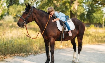 Cute,Little,Girl,With,Long,Hair,Riding,A,Horse,Outdoors.