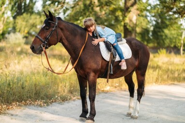 Cute,Little,Girl,With,Long,Hair,Riding,A,Horse,Outdoors.