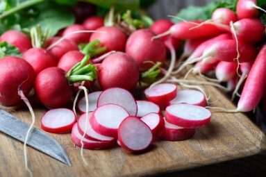 Close-up,Of,Fresh,Organic,Pink,Radish,Being,Sliced,On,A