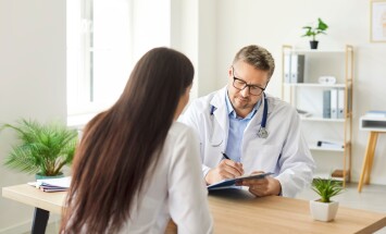 Focused,Doctor,Or,Nurse,Writes,A,Prescription,For,A,Female