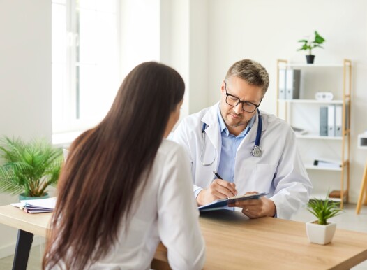 Focused,Doctor,Or,Nurse,Writes,A,Prescription,For,A,Female