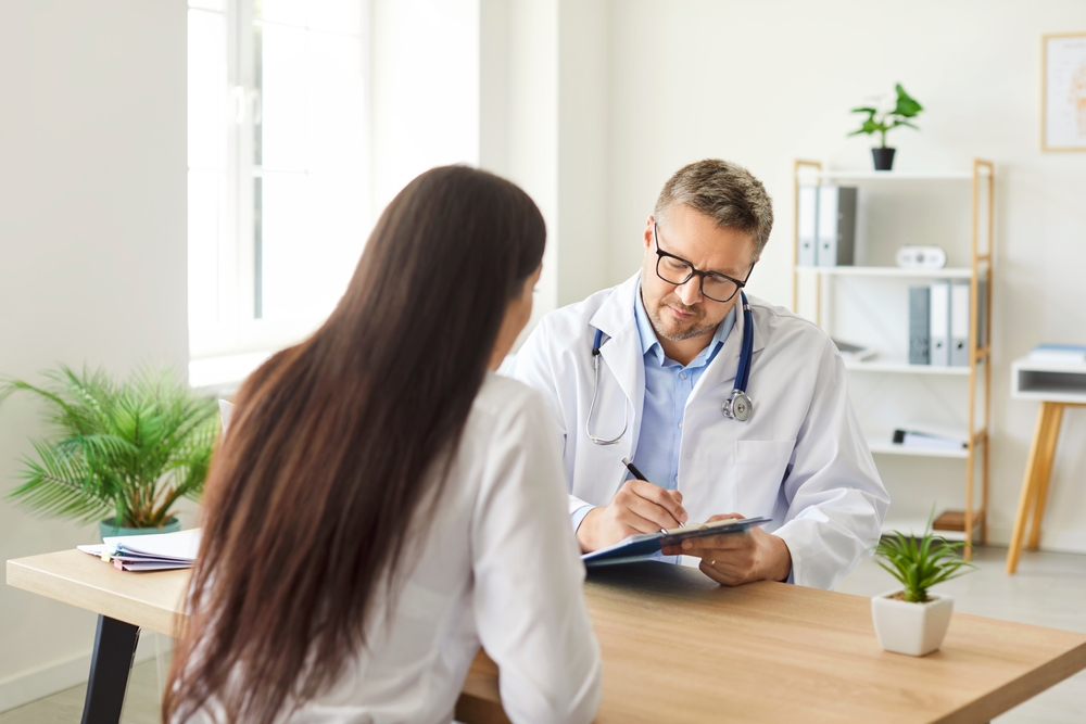 Focused,Doctor,Or,Nurse,Writes,A,Prescription,For,A,Female