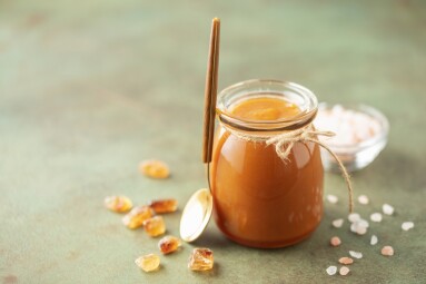 Glass,Jar,With,Salted,Caramel,And,Spoon,On,The,Table