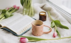 Close-up,Of,A,Pink,Coffee,Cup,With,Pink,Tulips,,Candle,