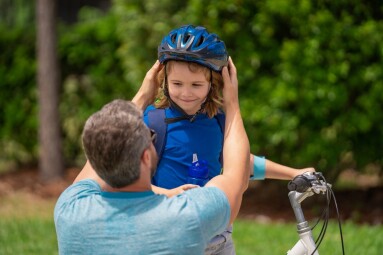 Father,And,Son,Riding,Bike,In,Park.,Child,In,Safety