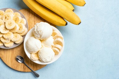 Ice,Cream,Scoops,And,Banana,Slices,In,Bowl,On,Blue