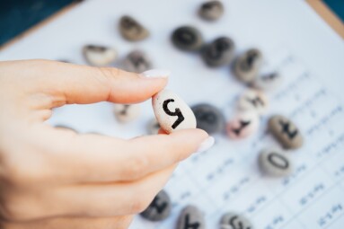 Woman,Numerologist,Hand,With,Pebble,Stone,With,Number,Five,5.