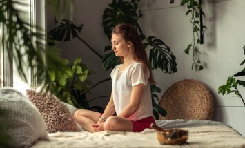 Young,Attractive,Woman,Practices,Yoga,At,Home,sitting,Cross-legged.yoga,Mudra.relaxation,And