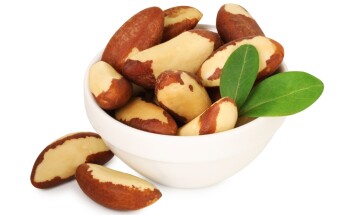 Tasty,Brazil,Nuts,And,Green,Leaves,In,Bowl,Isolated,On