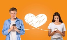 A,Young,Couple,Enjoys,Sharing,Affectionate,Messages,On,Their,Smartphones,