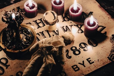 A,Dark,Atmospheric,Setting,With,An,Ouija,Board,,Candles,,And