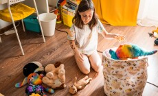 Child,Cleans,Up,Her,Toys,In,The,Room.