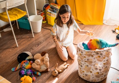 Child,Cleans,Up,Her,Toys,In,The,Room.