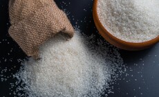 White,Sugar,Spilling,From,A,Burlap,Sack,Beside,A,Full