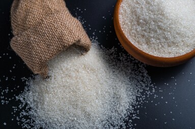 White,Sugar,Spilling,From,A,Burlap,Sack,Beside,A,Full