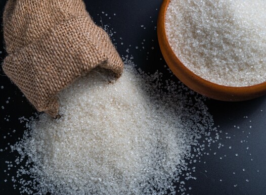 White,Sugar,Spilling,From,A,Burlap,Sack,Beside,A,Full
