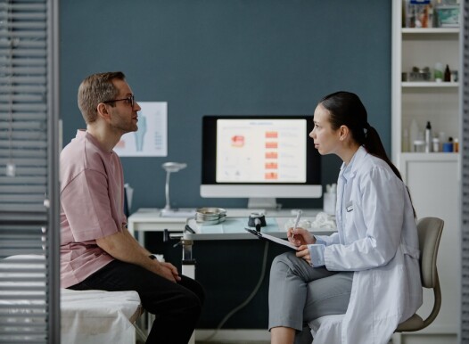Caucasian,Middle,Aged,Man,Sitting,On,Examination,Table,Consulting,With