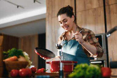 A,Joyful,Woman,Enjoying,Her,Time,Cooking,In,A,Modern