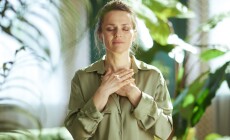 A,Middle-aged,Woman,Stands,With,Her,Hands,Over,Her,Heart