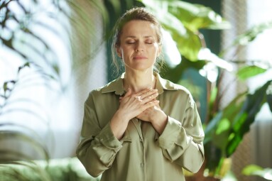 A,Middle-aged,Woman,Stands,With,Her,Hands,Over,Her,Heart