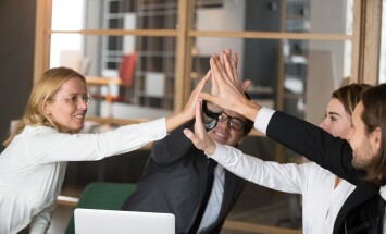Happy business team giving high-five together promising engageme