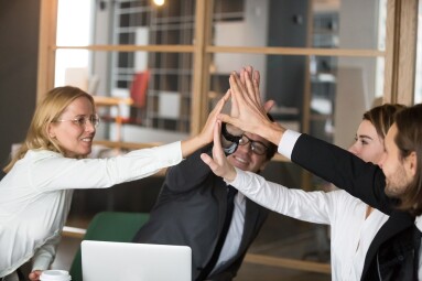 Happy business team giving high-five together promising engageme