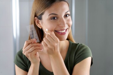 Close-up,Of,Smiling,Girl,Applying,Acne,Treatment,Anti-pickel,Patch,On