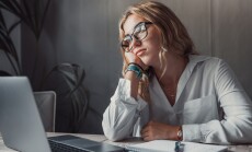 Discontented,Thoughtful,Woman,With,Hand,Under,Chin,Bored,At,Work,