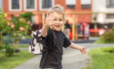 Smiling,Preschool,Child,With,Backpack,Waving,Outdoors,Before,School.,Blond