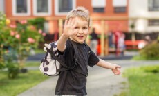 Smiling,Preschool,Child,With,Backpack,Waving,Outdoors,Before,School.,Blond