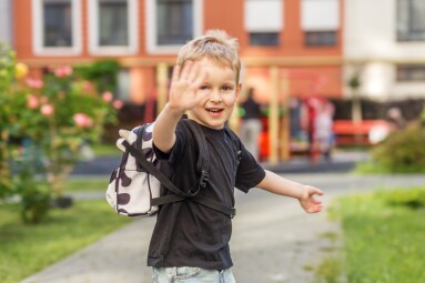Smiling,Preschool,Child,With,Backpack,Waving,Outdoors,Before,School.,Blond