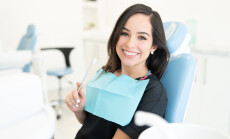 Smiling,Caucasian,Mid,Adult,Woman,Holding,Toothbrush,In,Dental,Clinic