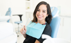 Smiling,Caucasian,Mid,Adult,Woman,Holding,Toothbrush,In,Dental,Clinic