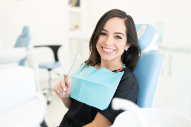 Smiling,Caucasian,Mid,Adult,Woman,Holding,Toothbrush,In,Dental,Clinic