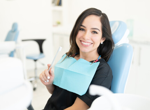 Smiling,Caucasian,Mid,Adult,Woman,Holding,Toothbrush,In,Dental,Clinic
