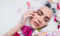 Sensual,Woman,Touching,Face,While,Taking,Milk,Bath,With,Rose