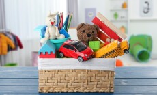 Wicker,Basket,With,Many,Different,Toys,On,Blue,Table,In