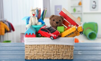 Wicker,Basket,With,Many,Different,Toys,On,Blue,Table,In
