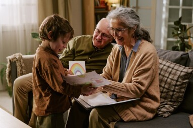 Senior,Grandparents,Smiling,And,Reviewing,Childs,Drawing,With,Young,Boy