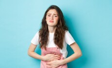 Image,Of,Sad,Young,Woman,Frowning,,Holding,Hands,On,Stomach,