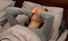 A,Young,Woman,Lying,In,Bed,Covering,Her,Face,With