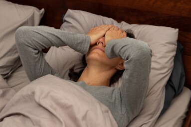 A,Young,Woman,Lying,In,Bed,Covering,Her,Face,With