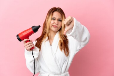 Teenager,Blonde,Girl,Holding,A,Hairdryer,Over,Isolated,Pink,Background